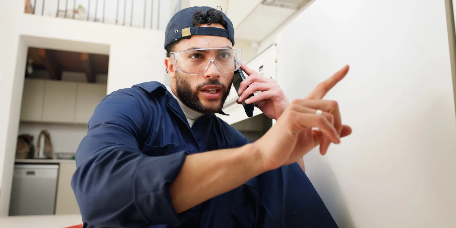 Plombier au téléphone guidant un client pendant une urgence